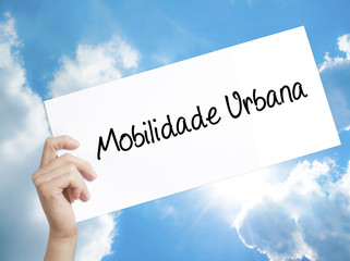 Mobilidade Urbana (Urban Mobility in Portuguese Sign on white paper. Man Hand Holding Paper with...