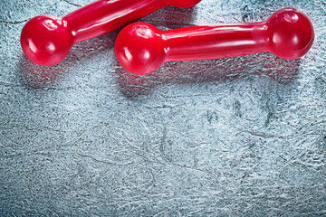 Pair of red dumbbells on silver background fitness concept