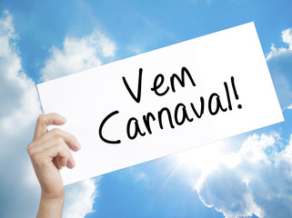 Carnival is Coming (in Portuguese) Sign on white paper. Man Hand Holding Paper with text. Isolated on sky background