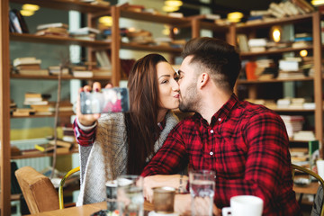 Self portrait making at restaurant couple enjoying together. Photo mobile posing for social networks.