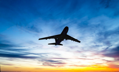 The plane flies in the sky against the background of clouds