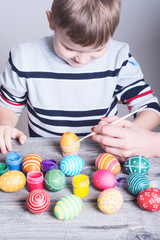 Fototapeta na wymiar child painting easter eggs