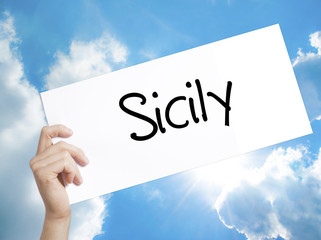 Sicily  Sign on white paper. Man Hand Holding Paper with text. Isolated on sky background.