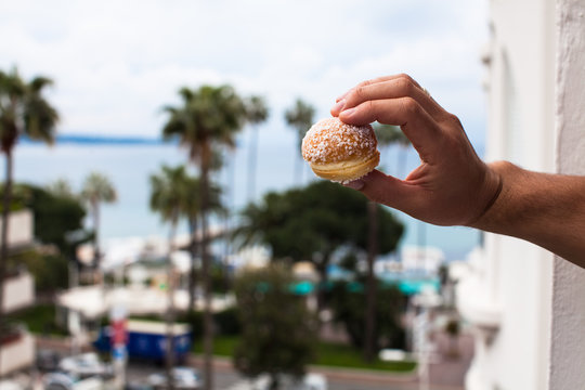 Man hand holding  famous tarte tropezienne dessert.