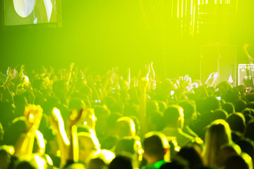 Crowd at concert and blurred stage lights .
