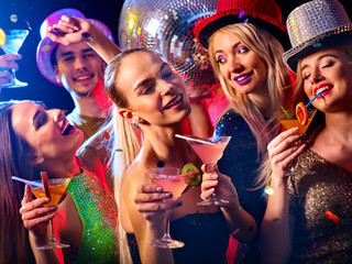 Cocktail party with group people dancing and drink cocktail. Happy women in evening dresses and men...