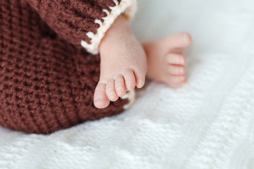 Newborn baby feet on the background of a bright rug wool
