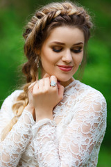 Portrait of a beautiful bride, outdoors, soft focus. The girl is young, with modern hair, makeup and jewelry