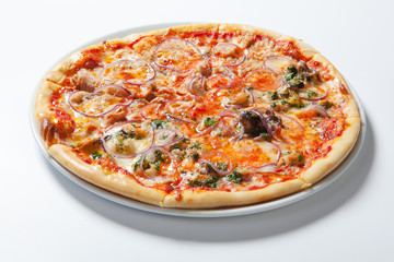 Pizza with onion, ham, cheese and tomato. White background