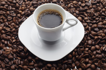 Cup and coffee over beans background