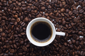 Cup and coffee over beans background