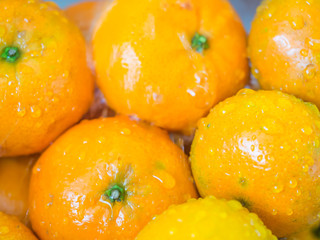 Closeup of oranges and drops. Cleaning fruits with water.