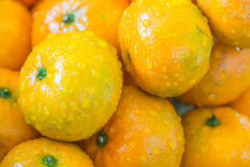 Closeup of oranges and drops. Cleaning fruits with water.