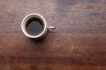 Cup of coffee with beans over wooden background