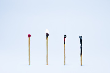 Four matches in a raw erect the first rod is not flammable. Second and third rods ignited. Four rod as charcoal. On white background.