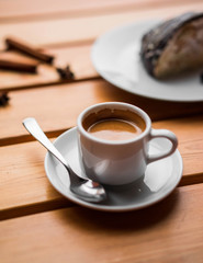 Cake with chocolate glaze and cappuccino on wooden table