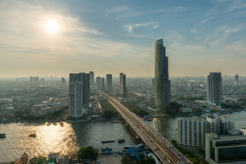 Bangkok city skyline and skyscraper along Chao phraya river in sunset time at Bangkok, Thailand.