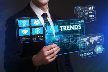 Business, Technology, Internet and network concept. Young businessman working on a virtual screen of the future and sees the inscription: Trends