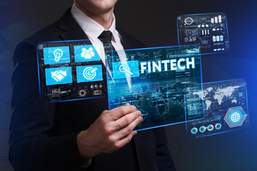 Business, Technology, Internet and network concept. Young businessman working on a virtual screen of the future and sees the inscription: Fintech