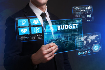 Business, Technology, Internet and network concept. Young businessman working on a virtual screen of the future and sees the inscription: Budget