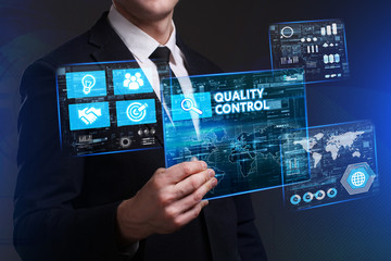Business, Technology, Internet and network concept. Young businessman working on a virtual screen of the future and sees the inscription: Quality control