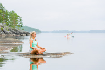 Young woman Yoga at the lakeside