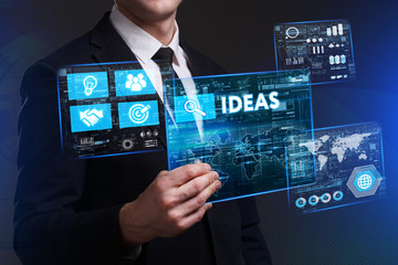 Business, Technology, Internet and network concept. Young businessman working on a virtual screen of the future and sees the inscription: Ideas