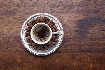 Cup of coffee and beans over wooden background - Powered by Adobe