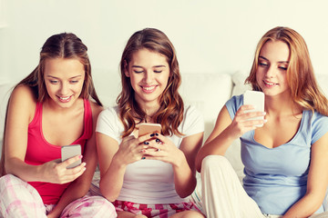 friends or teen girls with smartphone at home