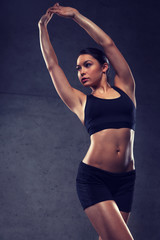 young woman posing and showing muscles in gym