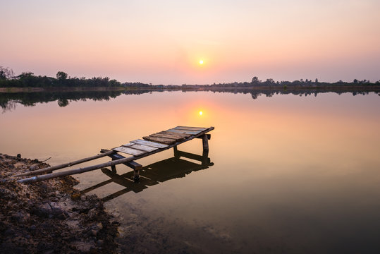 wooden bridge at the lake on sunset