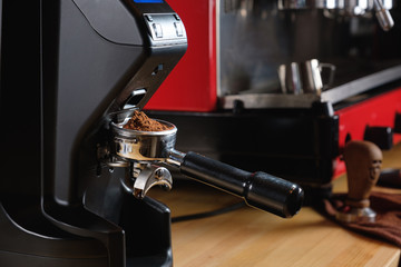 Black electric grinder is on a wooden table