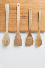 Wooden Spoons on Chopping Board on White Background.