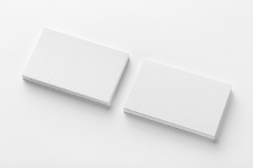 Mockup of two blank horizontal business cards stacks at white textured background.