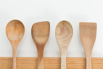 Wooden Spoons on Chopping Board on White Background.