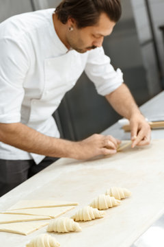 Professional pastry chef preparing croissants