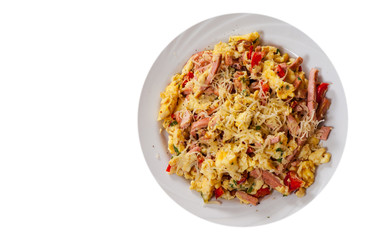 scrambled eggs with ham, vegetables and cheese in a plate. top view. isolated on white