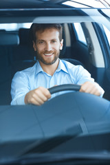 Handsome mature man sitting in a new car