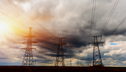 High-voltage power lines during fiery sunrise