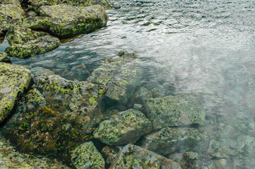 Blue transparent water and stones