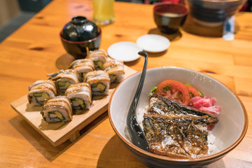 Rice with grilled Mackarel fish ( japanese call ''Saba Don'')
with Anago sushi sea eel sushi on wooden plate - Japanese food.