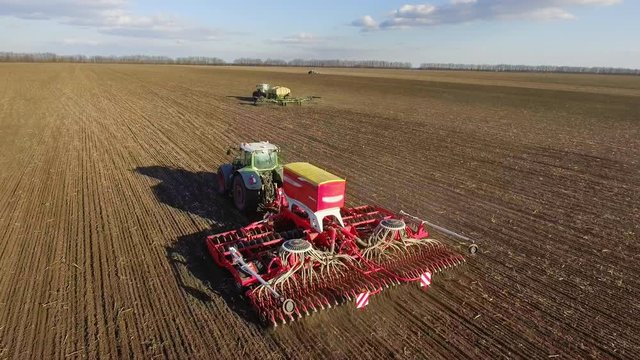 Spring sowing campaign - two tractors pull seeders, a rural landscape