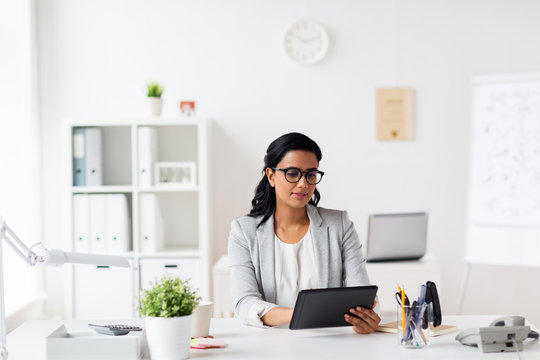smiling businesswoman with tablet pc at office