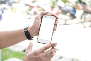asia man smoking and playing smartphone