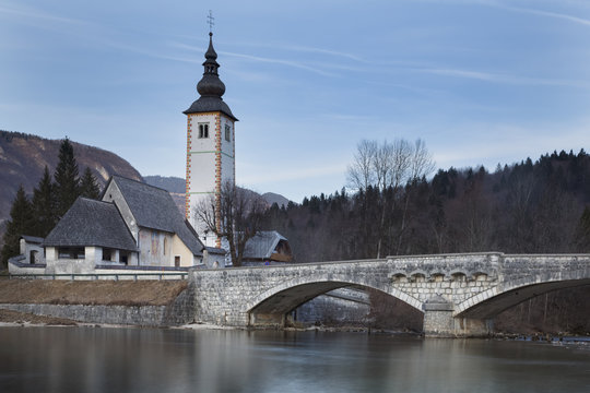 Europe, Slovenia, Upper Carniola. Church of Sv. John the Baptist and the stone bridge by the Bohinj lake