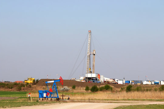 oilfield with pump jack and oil drilling rig