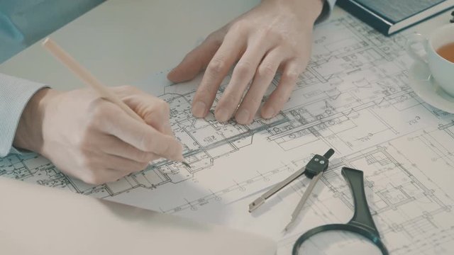 Male architect draws a construction project.