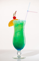 Exotic cocktail green decorated with orange and cherry