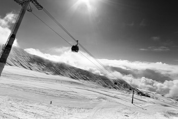 Black and white view on gondola lift and ski slope at nice sunny day © BSANI