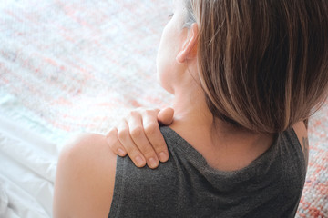 Donna con dolore alla spalla, cervicale o collo